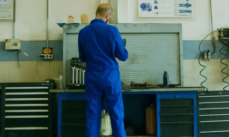 Profissional usando uniforme operacional azul em uma oficina