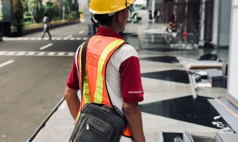 Profissional com colete de trabalho em ambiente externo