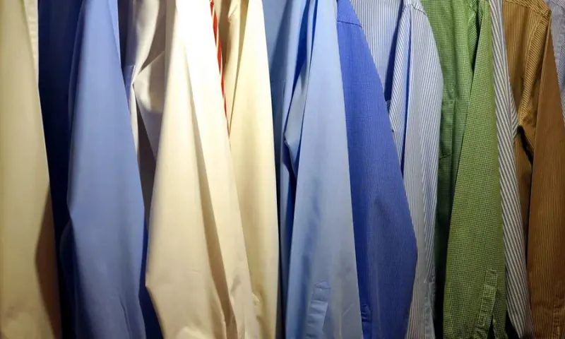 Camisas sociais de diferentes cores organizadas em cabides